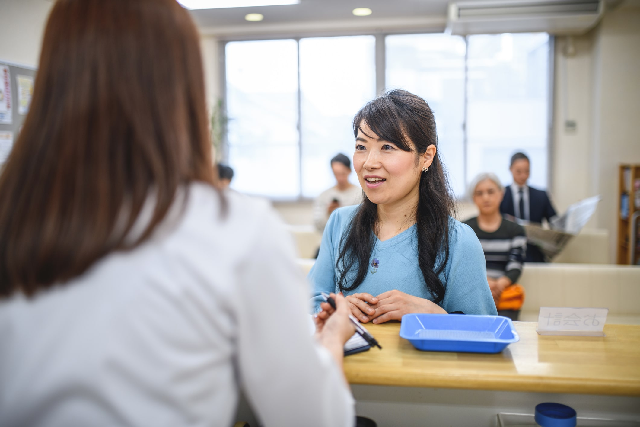 a woman in a blue shirt is talking to another woman