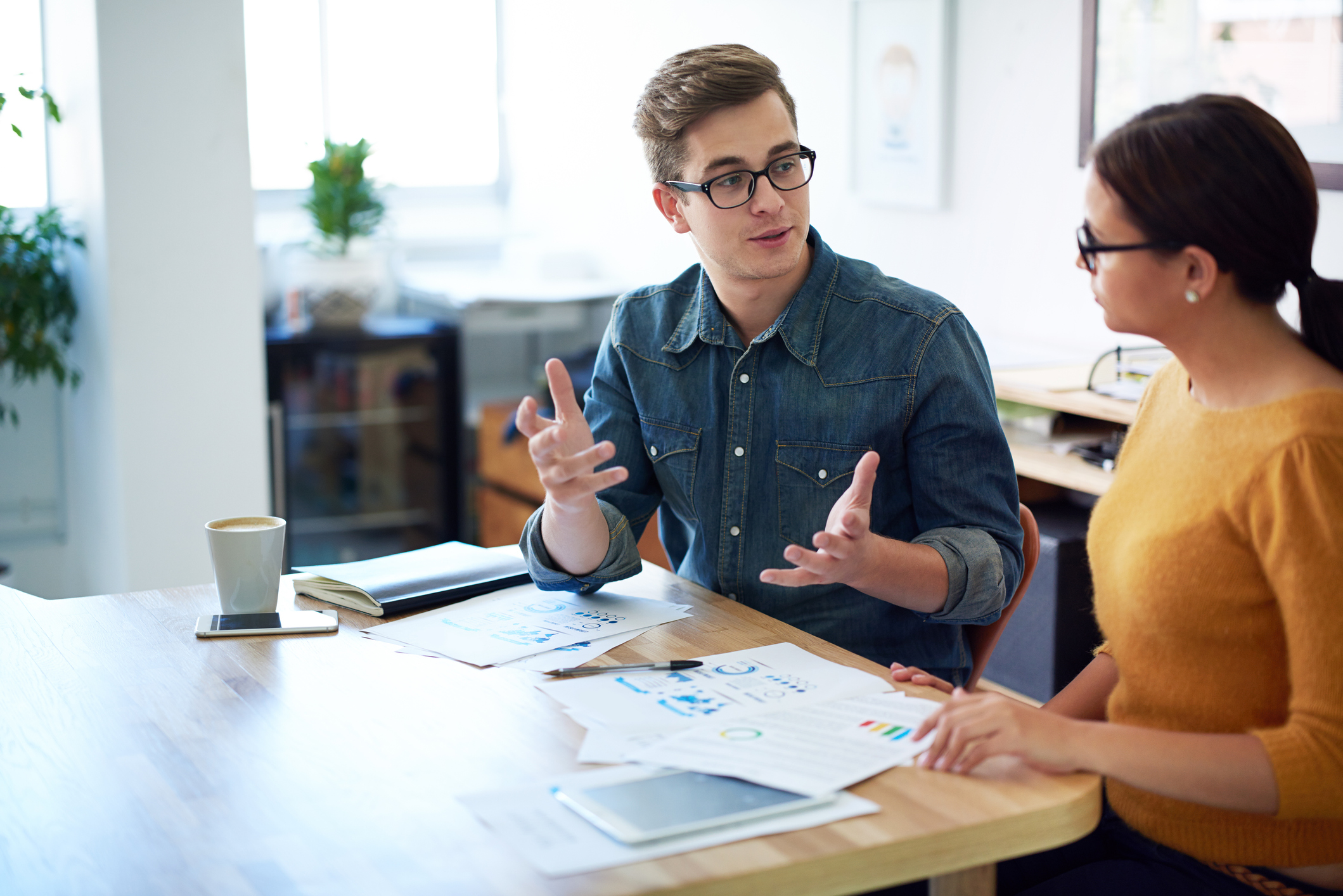 a man and a woman are sitting at a table talking