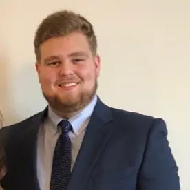 a man in a suit and tie is smiling for the camera