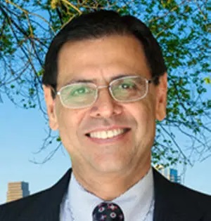 a man wearing glasses and a suit and tie is smiling