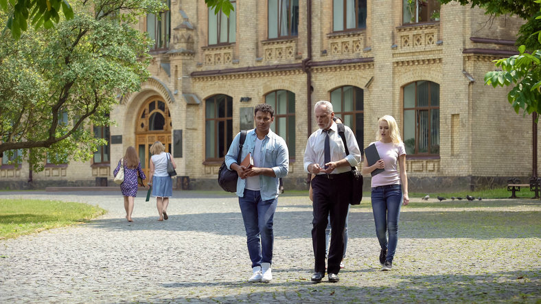 a group of people walking in front of a brick building