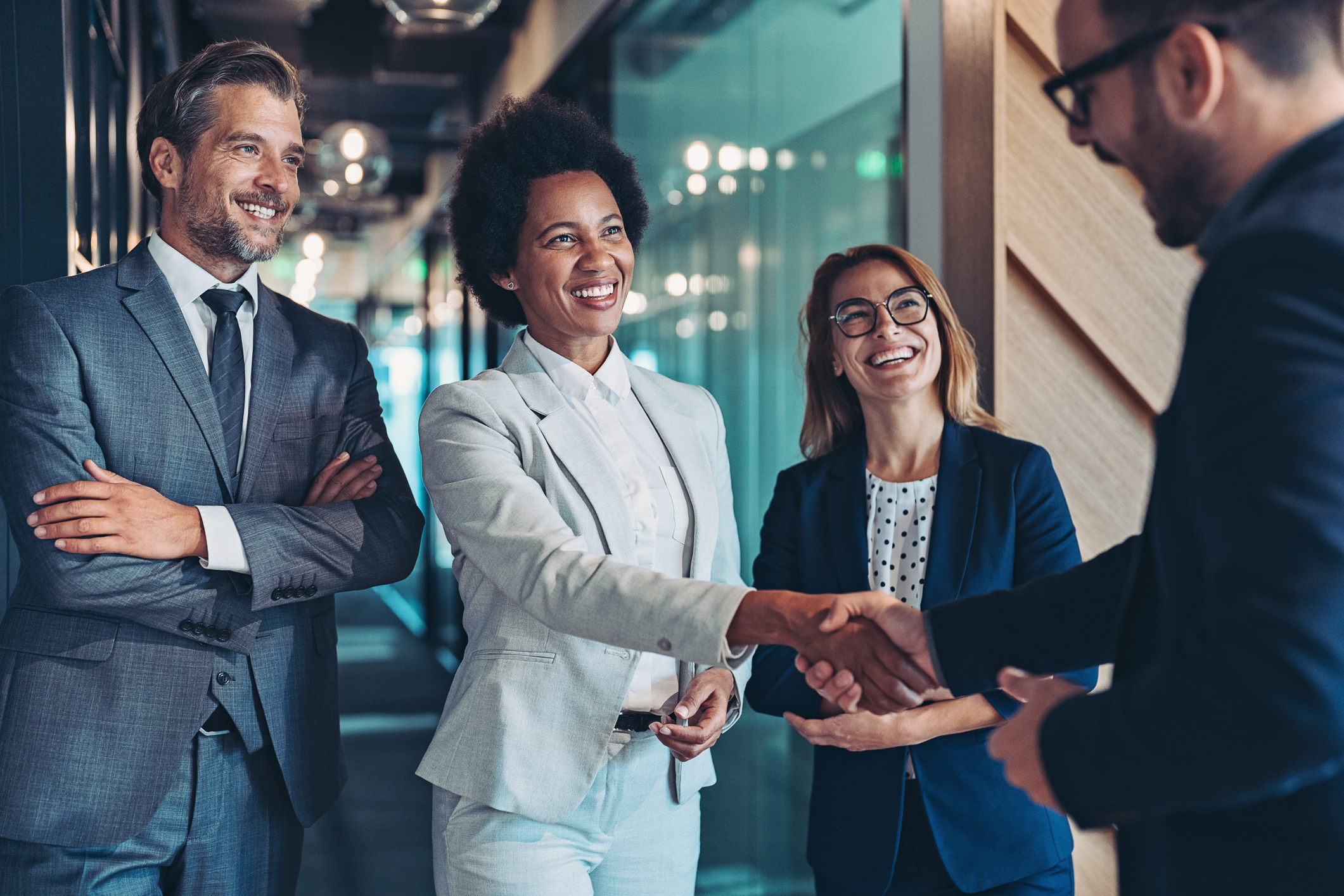 a group of business people shaking hands in a hallway