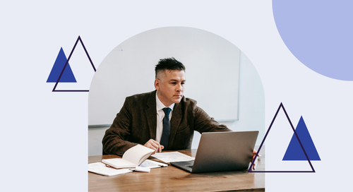 man sitting at his desk working on his laptop