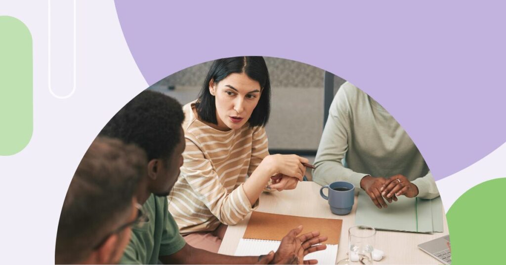 Woman at a table speaking to colleagues
