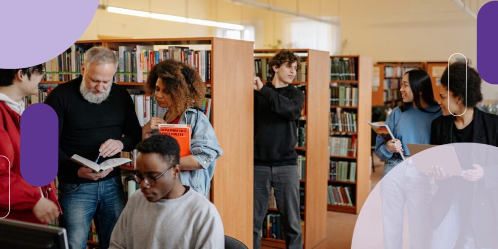 An older man and younger woman looking at a book in a library