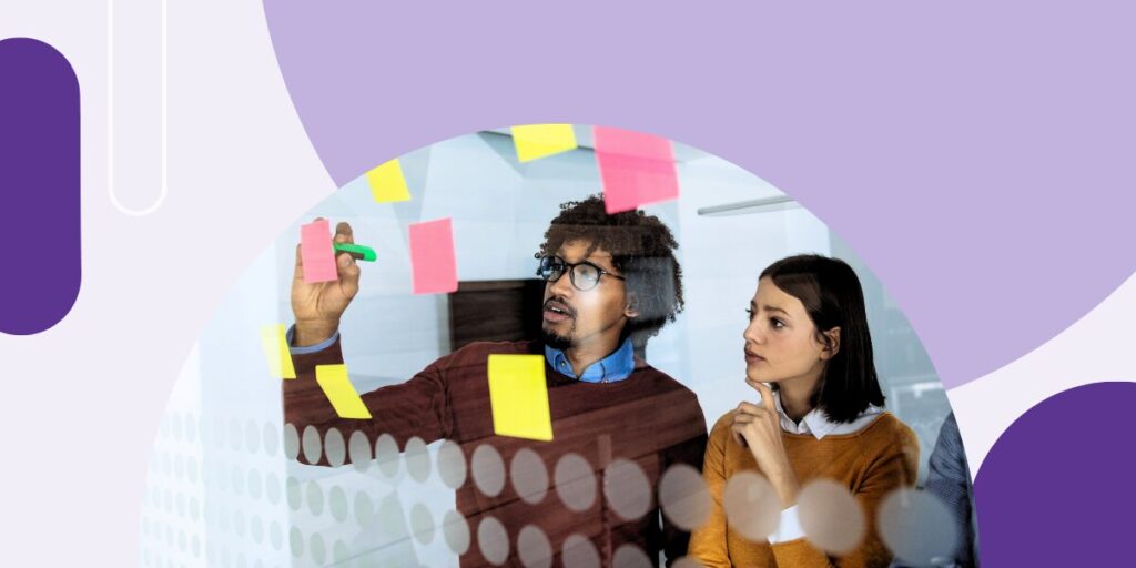 Two colleagues looking at a wall of post-it notes