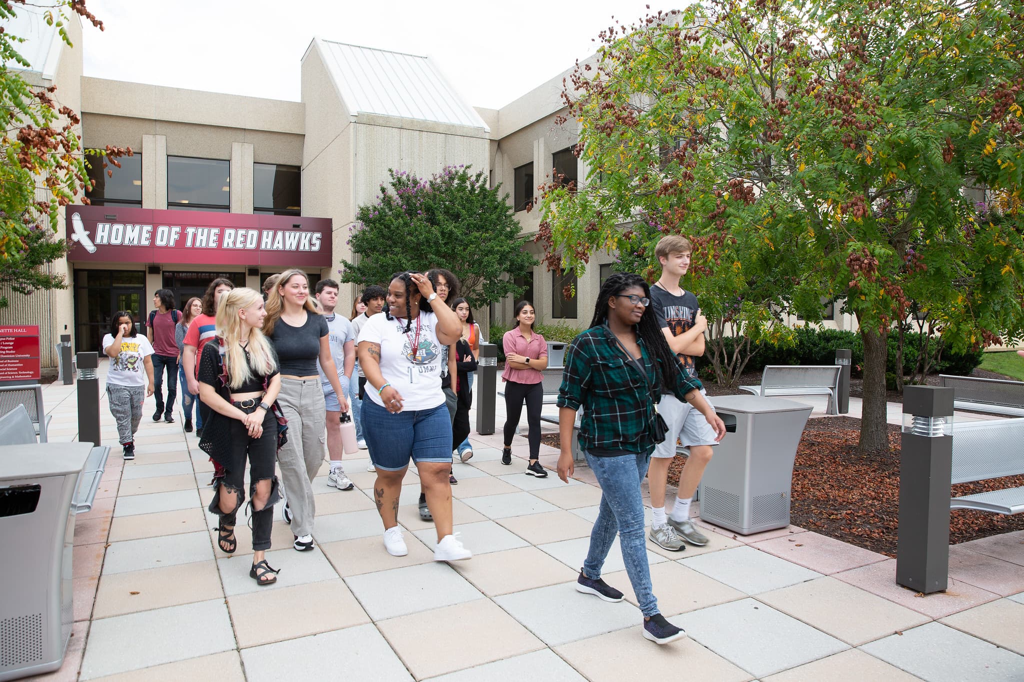 students-on-campus-with-red-hawk-banner