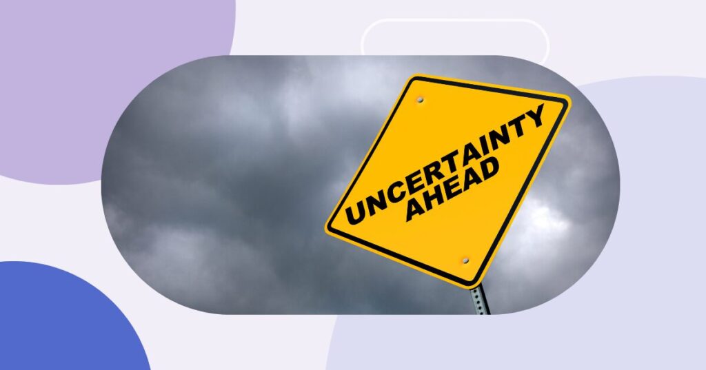 Yield sign against dark, cloudt sky. The sign reads: "uncertainty ahead".