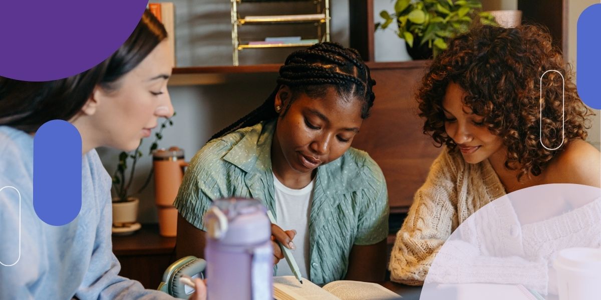 Three female students working at a table